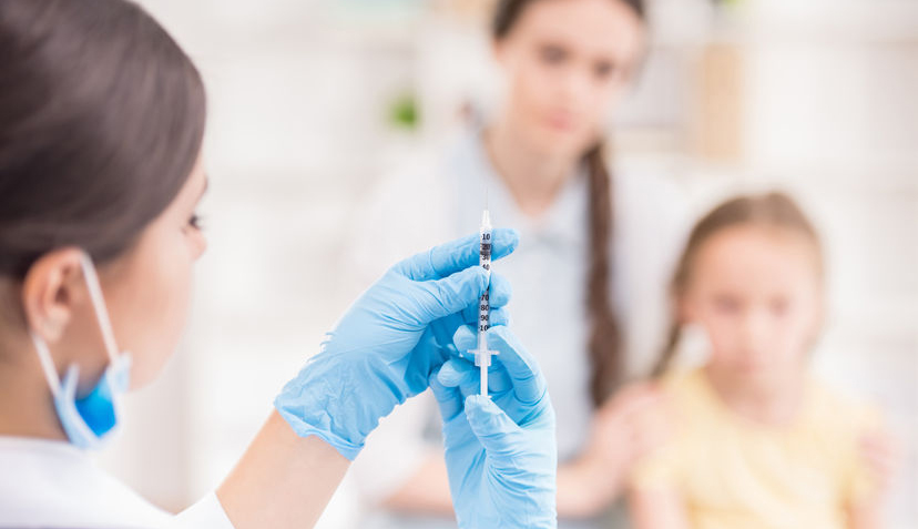 doctor giving vaccination to girl